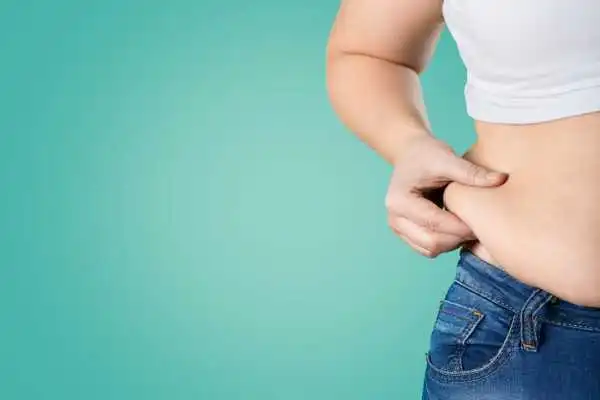 Image of woman pinching her love handles to show weight gain Whitnash